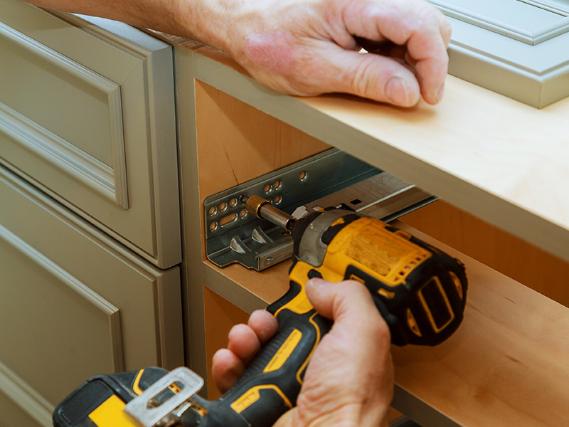 handyman hands close up with drill installing new cabinetry furniture clinton nj