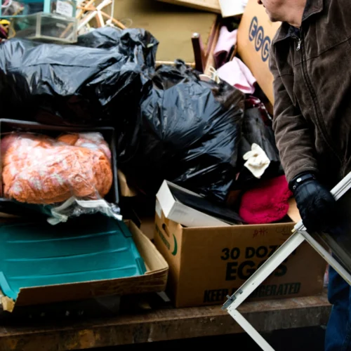 workman loading junk on dumpster